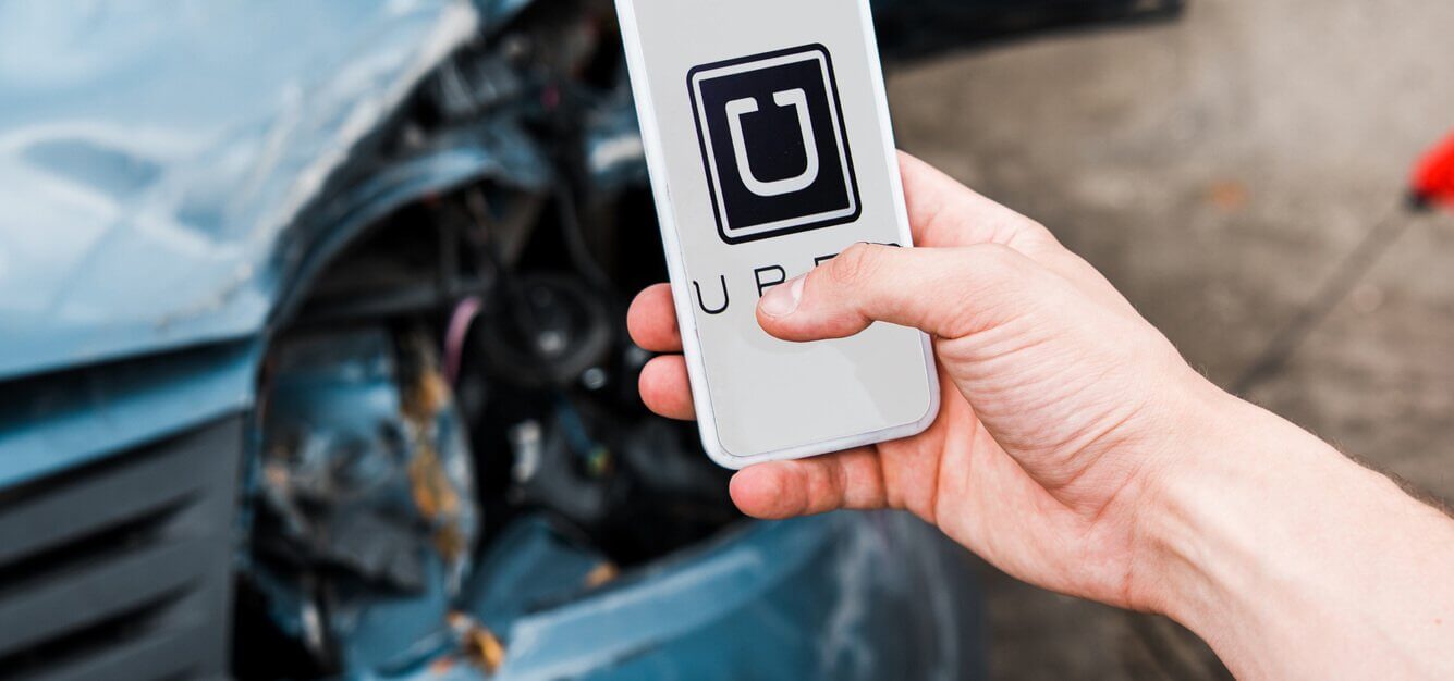 man holding phone after uber car accident in baltimore maryland