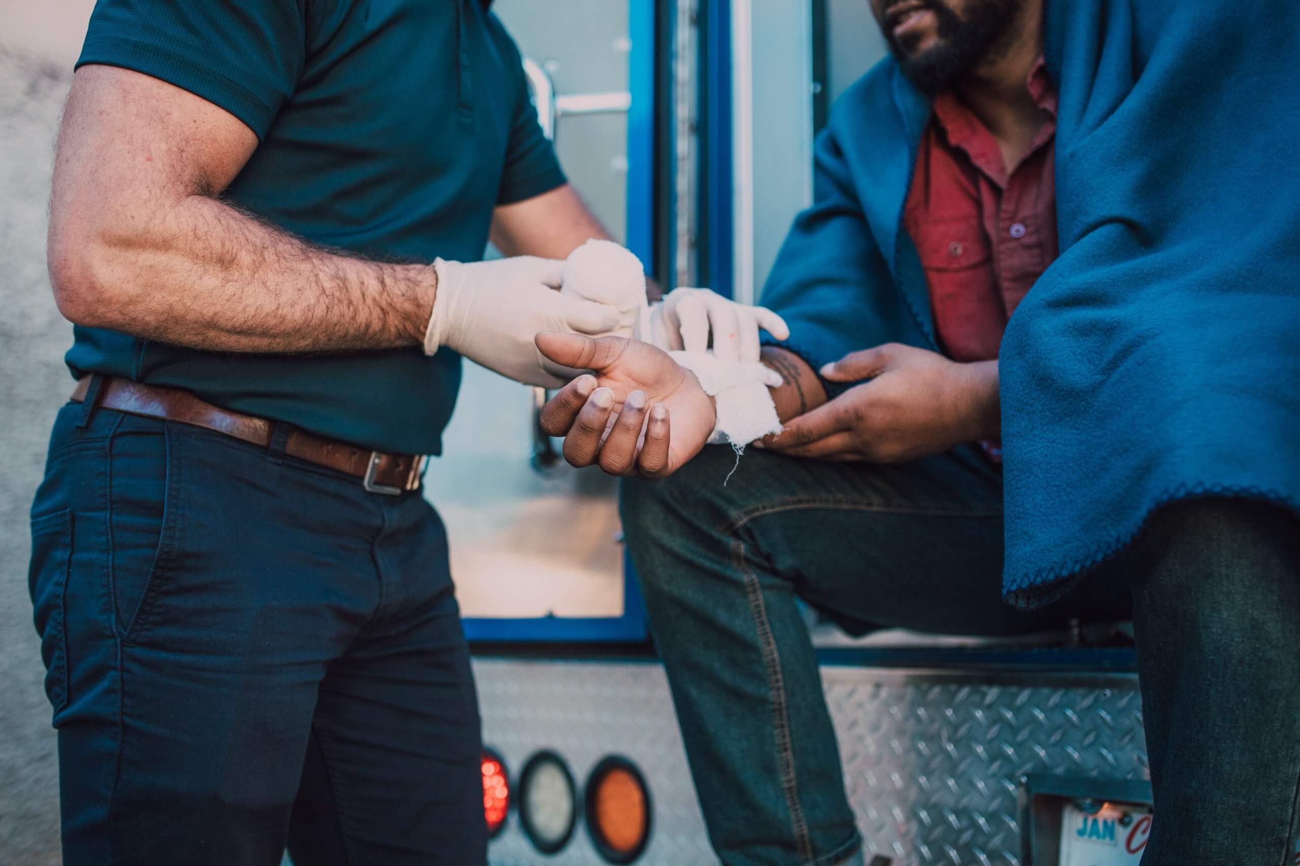 EMT treats man on the side of the road after an accident in Baltimore